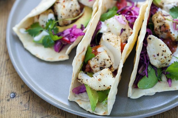 Three Fish Tacos side by side on a gray plate.