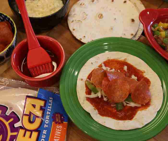 An Open-faced Azteca Pizza Taquito on a green plate.