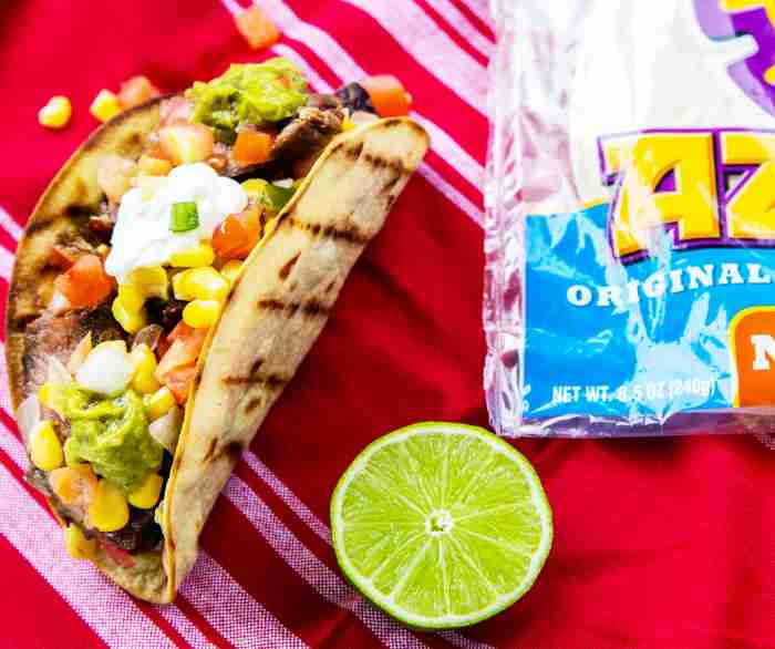 STUFFED BLACK BEAN TACOS on a red tablecloth next to a package of Azteca tortillas.
