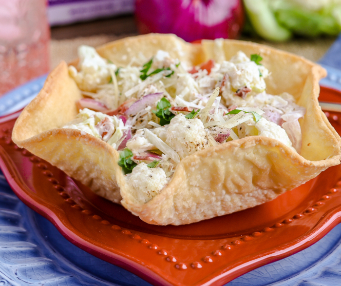 An Azteca Salad Shell with a cauliflower and chicken salad inside.