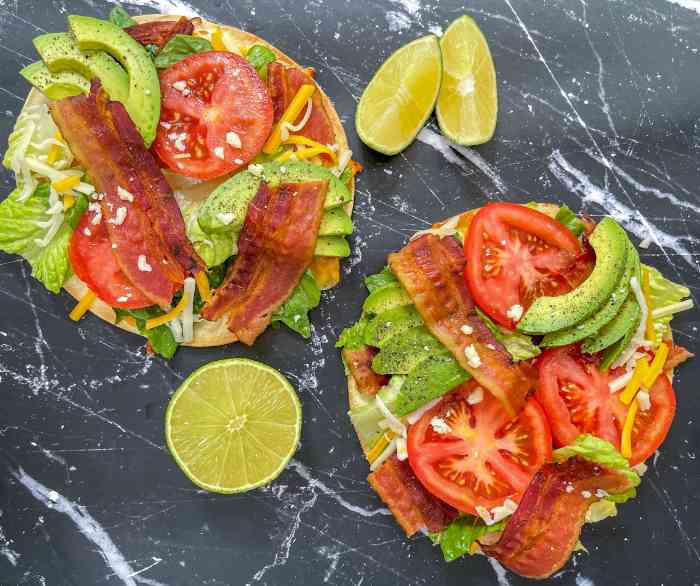Two BLT Tostadas side by side on a black marble tabletop.
