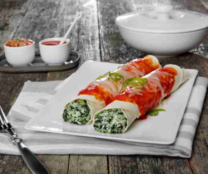 Two Spinach enchiladas on a white plate.