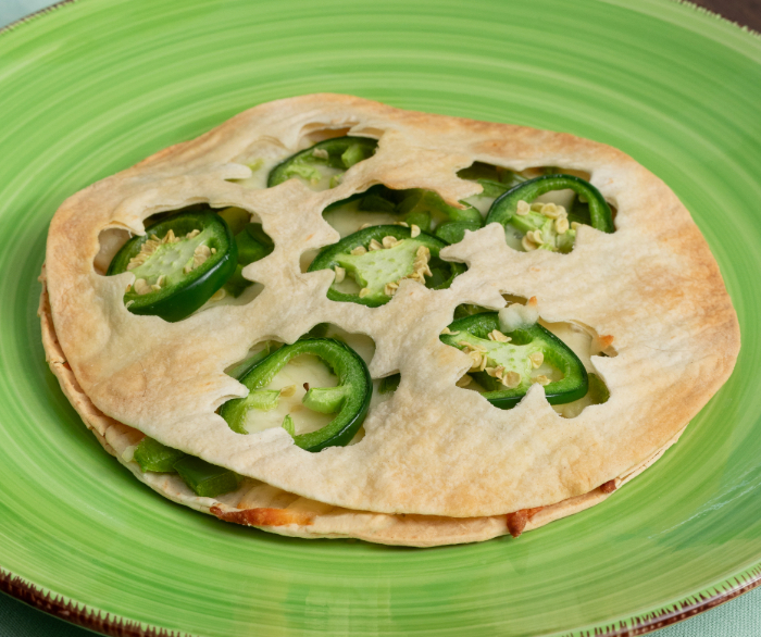 A jalapeno clover quesadilla on a green plate.