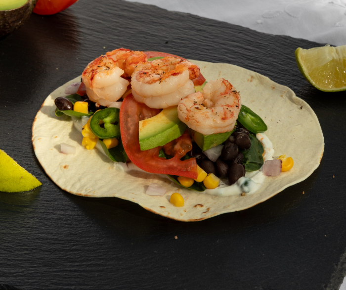 A Santa Fe shrimp taco on a black table.